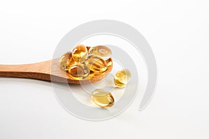 Cod liver oil omega 3 gel capsules in a wooden spoon