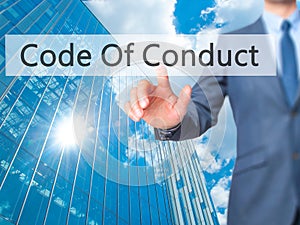 Code Of Conduct - Businessman hand pressing button on touch screen interface.
