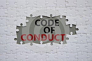 Code of conduct symbol. White Puzzle with words Code of conduct. Beautiful grey background. Business and Code of conduct concept.