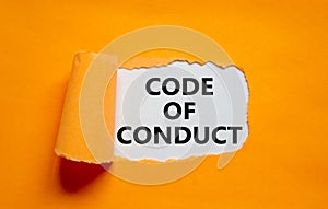 Code of conduct symbol. Words `Code of conduct` appearing behind torn orange paper. Beautiful orange background. Business, code photo