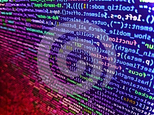 Code on dark background. Shallow depth of field, selective focus effect. Computer script coding source code on desktop monitor.