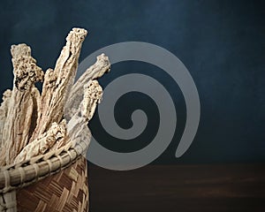 Codonopsis Root in basket on brown wooden table with black background. copy space.