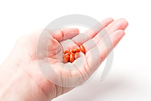 Coenzyme q10 supplement capsules in hand close-up on  white background