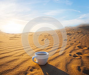 Cofee cup on the sand at the sunset