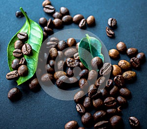 Coffe beans and green leaf on black background