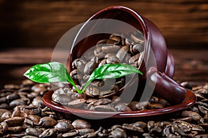 Coffe beans scattered from cup and leaves