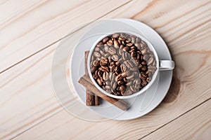 Coffe beans in white cup with cinamone.