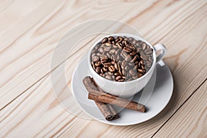 Coffe beans in white cup with cinamone.