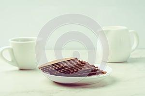Coffe white cup with cookies and milk/breakfast in white ceramic ware and cookies on white background. Selective focus