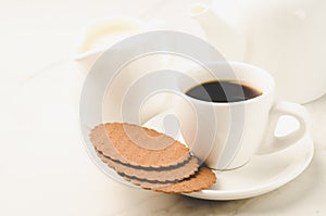 Coffe white cup with cookies and milk/Coffe white cup with cookies and milk on white marble background. Selective focus