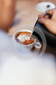 Coffee Art In Cup. Closeup Of Hands Making Latte Art