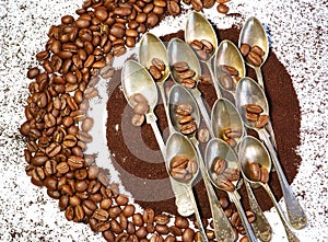 Coffee art on a table with coffeebeans and silverspoons