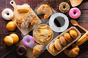 Coffee and assorted junk food multiple type on wooden table of top view