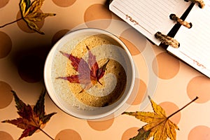 Coffee with autumn leaf on a table