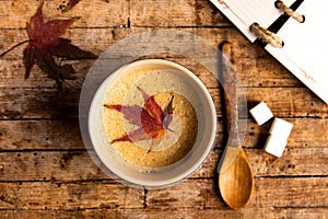 Coffee with autumn leaf on a table