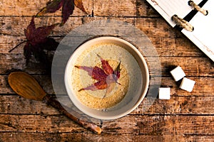 Coffee with autumn leaf on a table