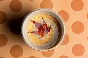 Coffee with autumn leaf on a table