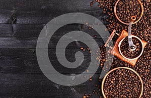 Coffee background, top view with copy space. Ground coffee, mill, bowl of roasted coffee beans on dark wooden background