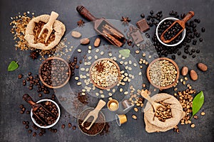Coffee background with various of roasted coffee beans and flavourful ingredients for make tasty coffee setup on dark stone