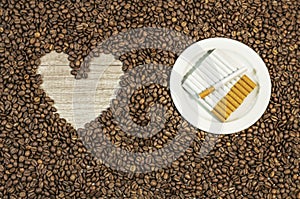 Coffee bean background with heart and many cigars on white plate