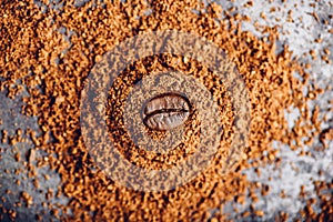 Coffee bean on heap of grinded coffee