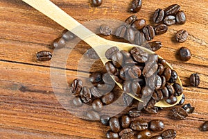 Coffee bean on wooden spoon, wooden table background