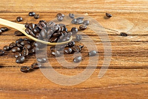 Coffee bean on wooden spoon, wooden table background