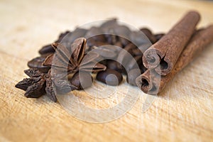 Coffee beans with anise and cinnamon on wooden background