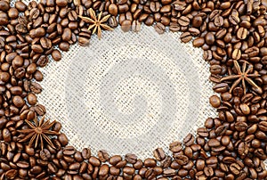 Coffee beans with anisetree stars oval frame on natural sacking background with space for your text.