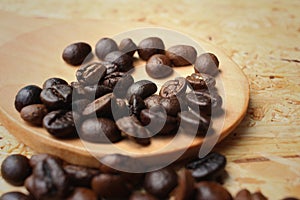 Coffee beans on background of brown wood.