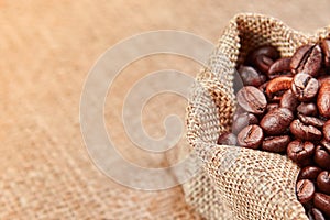 Coffee beans in a bag on a background of burlap.