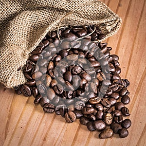 Coffee beans in bag over a wood table