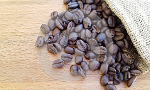 Coffee beans in a bag on wooden background