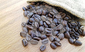 Coffee beans in a bag on wooden background