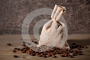 Coffee beans in bag and on wooden table