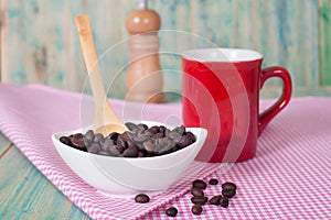 Coffee beans in bolw with cup