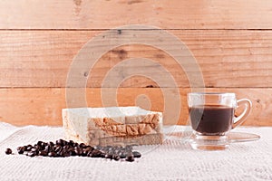 Coffee beans and bread and a glass of espresso.