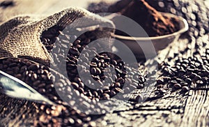 Coffee beans in burlap sack on old wooden table