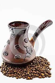 Coffee beans and ceramic cezve on a white background