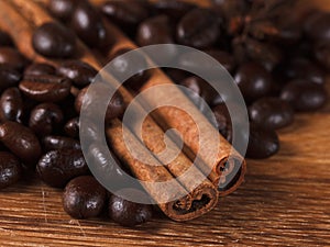Coffee beans with cinnamon and anise on wooden table
