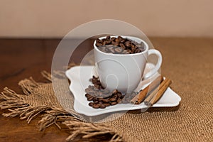 Coffee beans cinnamon cookie white cup and saucer