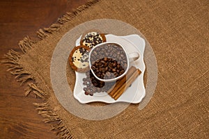 Coffee beans cinnamon cookie white cup and saucer