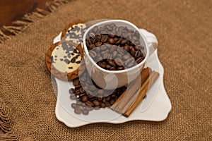 Coffee beans cinnamon cookie white cup and saucer