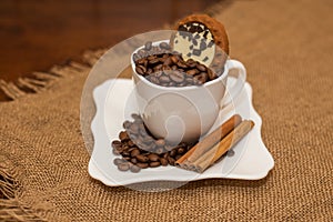 Coffee beans cinnamon cookie white cup and saucer