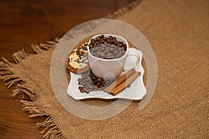 Coffee beans cinnamon cookie white cup and saucer