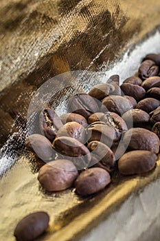 Coffee beans close up on expensive golden background