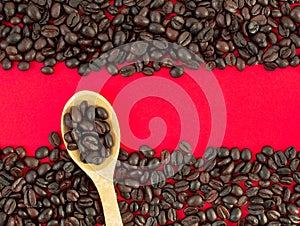 Coffee beans close-up on a red background and in a wooden spoon