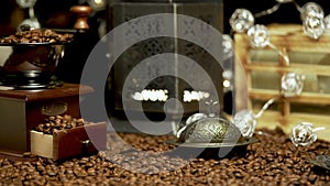 Coffee beans close up. Shot in slow motion of white coffee cup and coffee grinder.