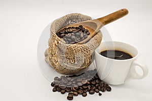 Coffee beans in Cloth bag and wooden spoon and coffee cup