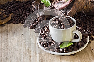 Coffee beans in coffee cup and leaves